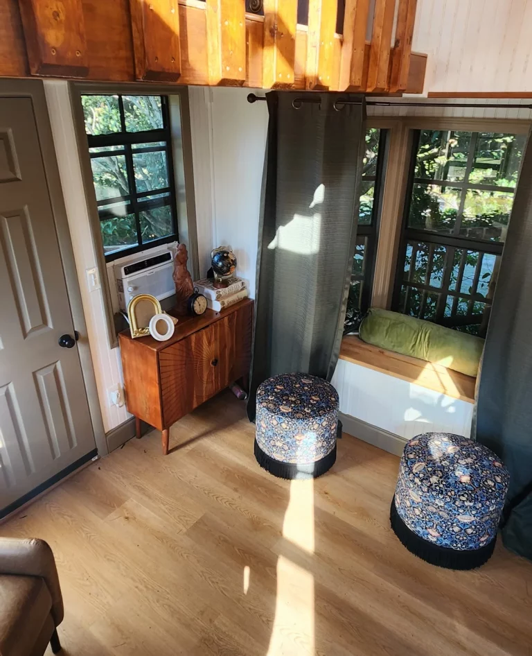 Interior of a cozy treehouse rental with wooden stairs and patterned ottomans, perfect for a romantic Florida getaway.