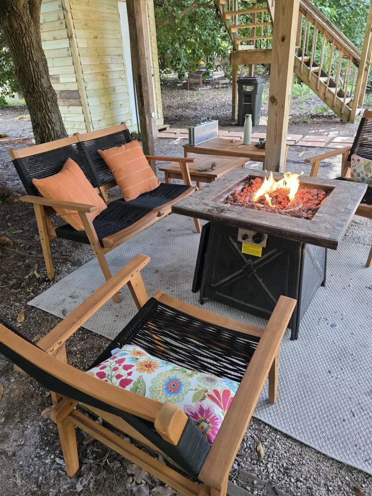 Cozy outdoor seating area with a fire pit at SunnyTops treehouse rental, perfect for relaxing getaways in Florida.