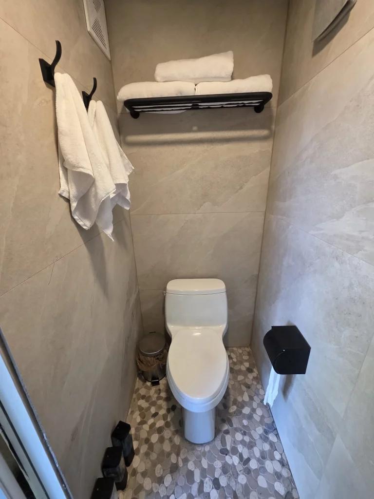 SunnyTops treehouse bathroom with stone tile and clean amenities. Perfect for relaxing treehouse getaways in Florida.