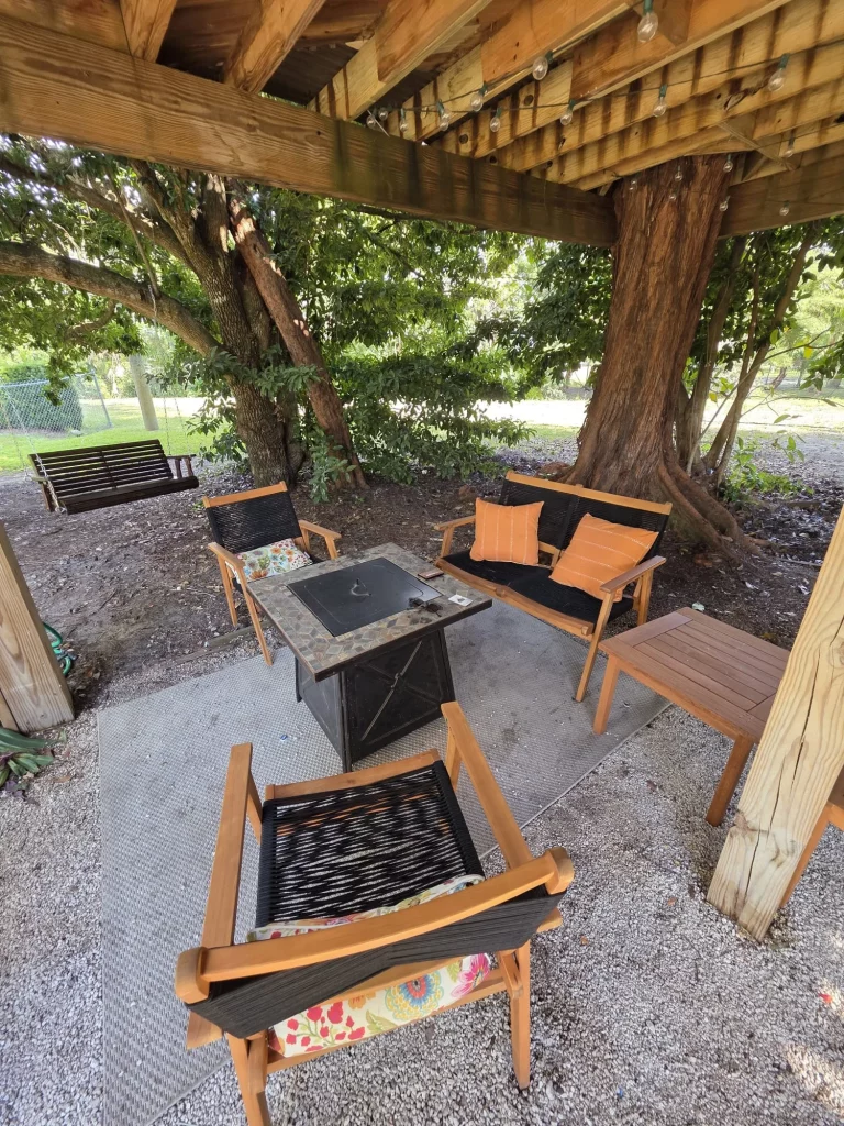 SunnyTops Treehouse outdoor seating area with fire pit and swing, perfect for treehouse getaways in Florida.