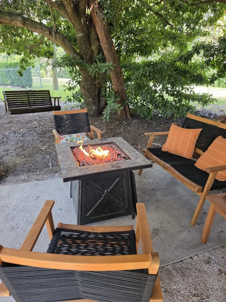 SunnyTops Treehouse outdoor area with fire pit, seating, and swing, perfect for romantic treehouse getaways in Florida.