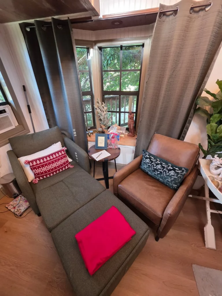 Cozy treehouse interior featuring armchairs, a small table, and a window view, perfect for a romantic treehouse getaway in Fl