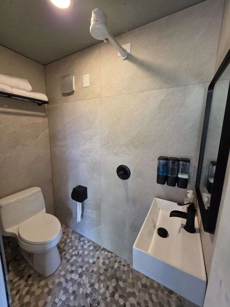 Modern treehouse bathroom interior with stone tile and clean amenities for a relaxing treehouse stay.