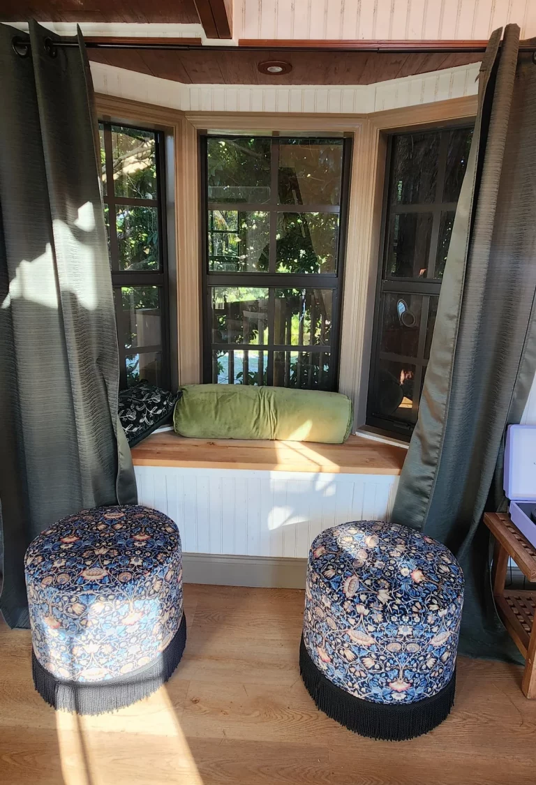 SunnyTops treehouse interior, featuring a window overlooking greenery, cozy seating, and a relaxing treehouse getaway in Flor