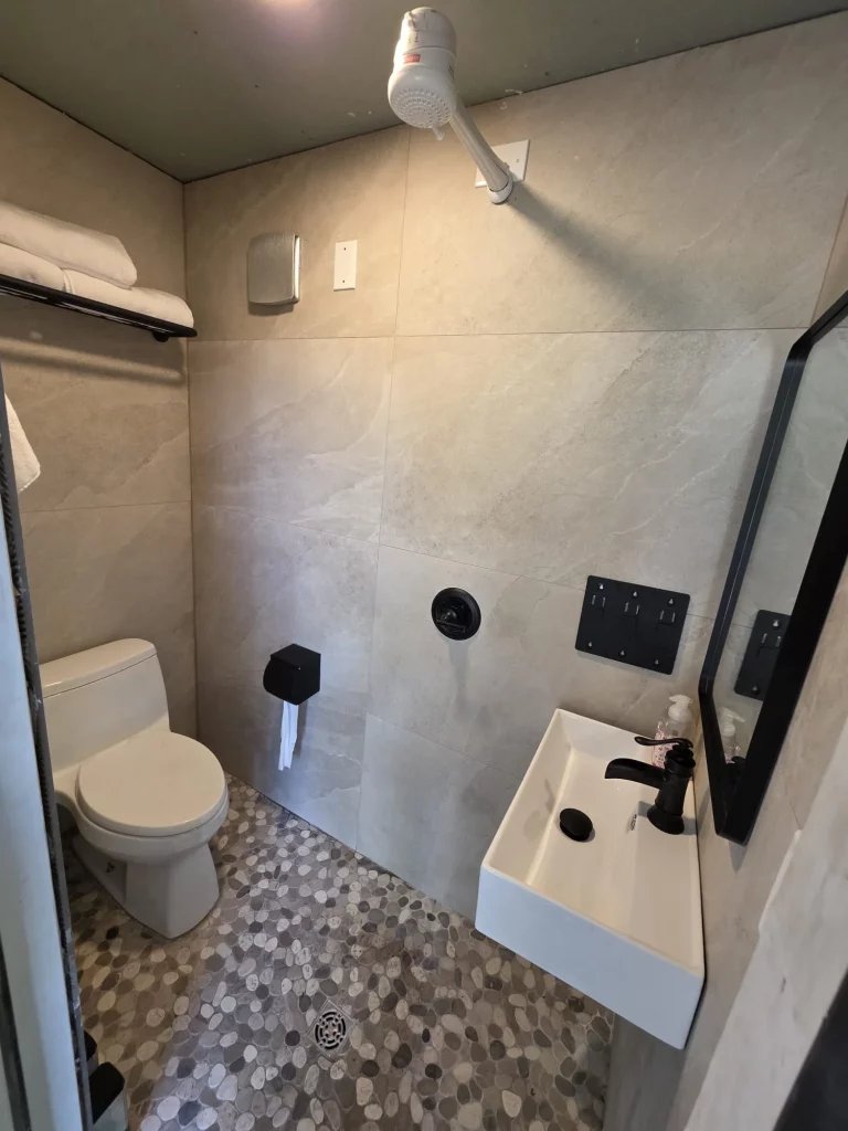 Treehouse bathroom interior with modern sink, stone tile floor. Ideal for treehouse getaways and relaxing stays in Florida.